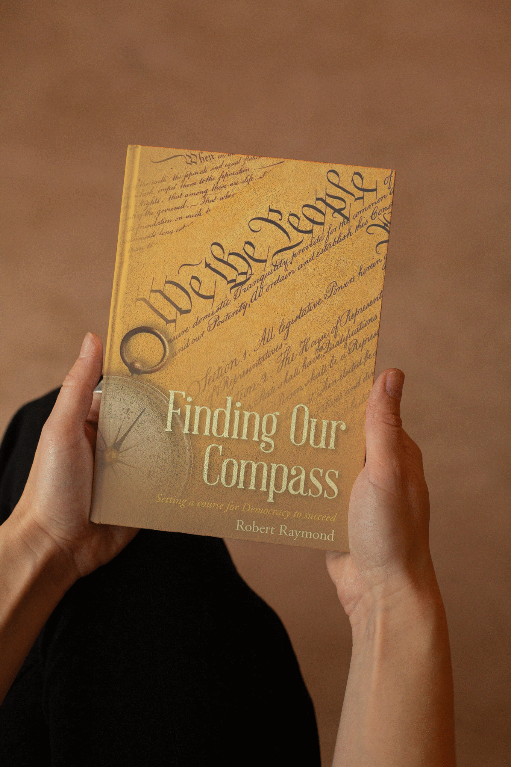 someone holding a copy of Finding Our Compass